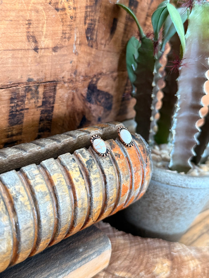 Copper oval stud earrings with white opal cabochon, visible stud setting