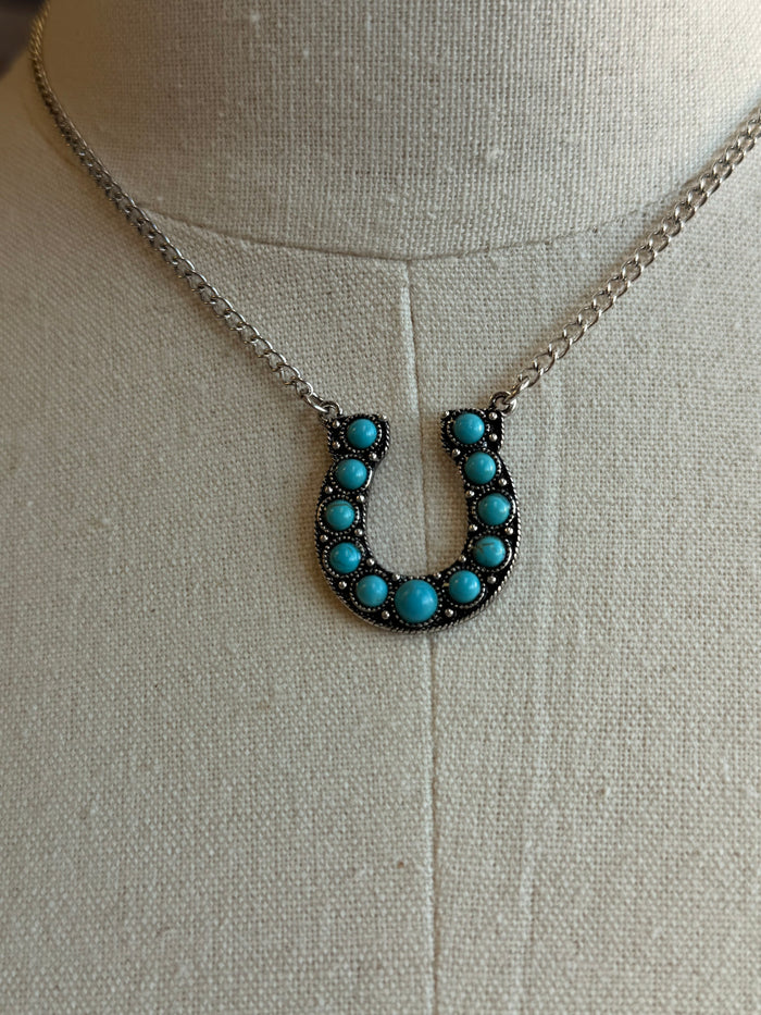 Turquoise horseshoe pendant necklace with silver chain and blue bead inlay horseshoe