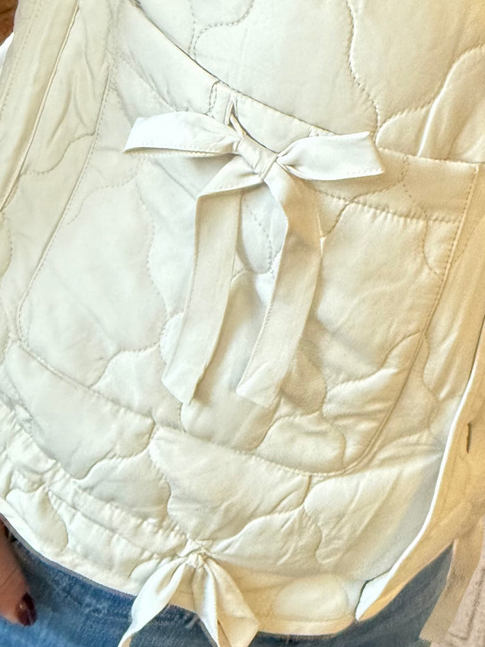 Ivory quilted puffer vest with tie detail at neckline