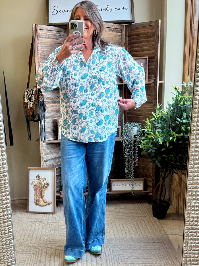 Turquoise printed button-front blouse with long sleeves and collared neckline