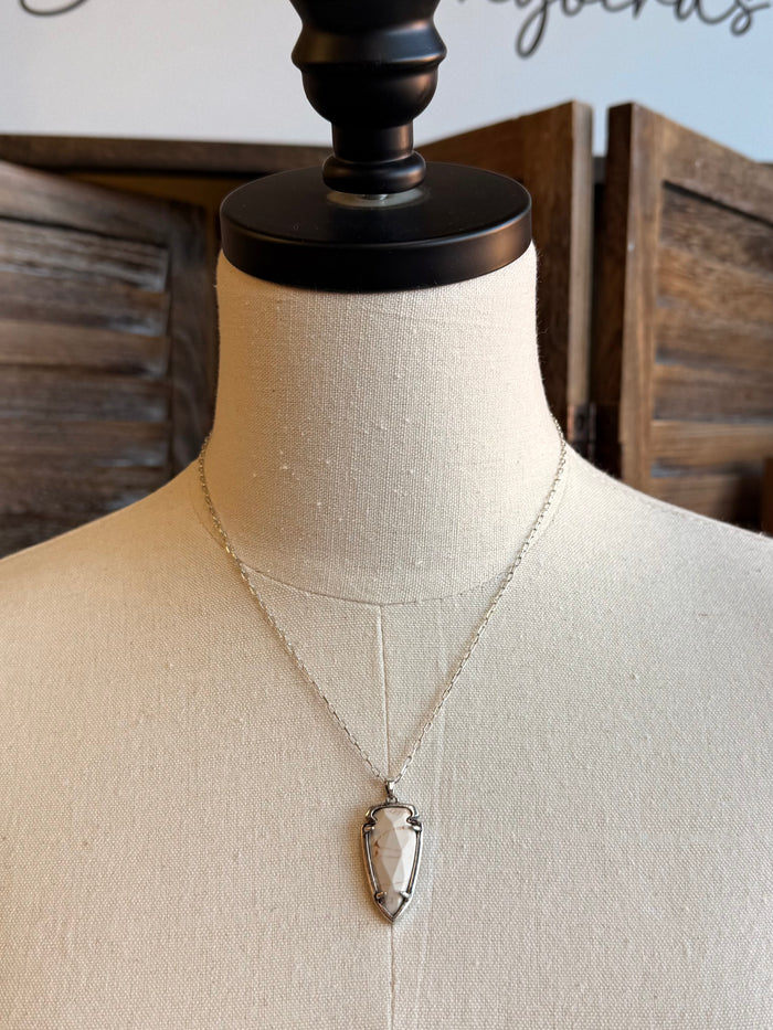 Arrowhead pendant necklace with white faceted stone in gold-tone setting on thin chain