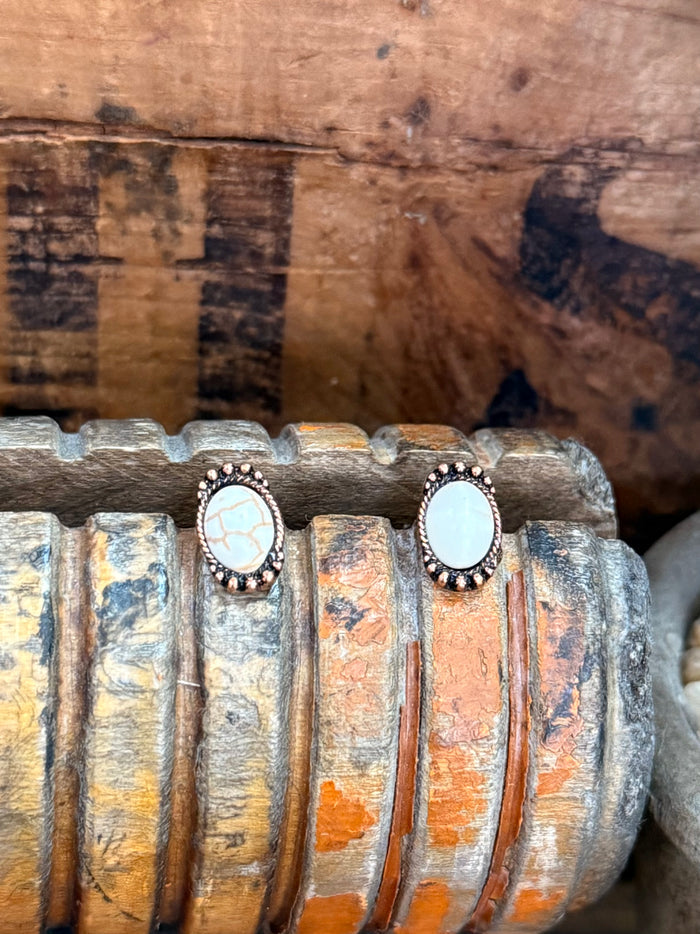 Copper oval stud earrings with bezel-set white opal cabochon, dark textured border