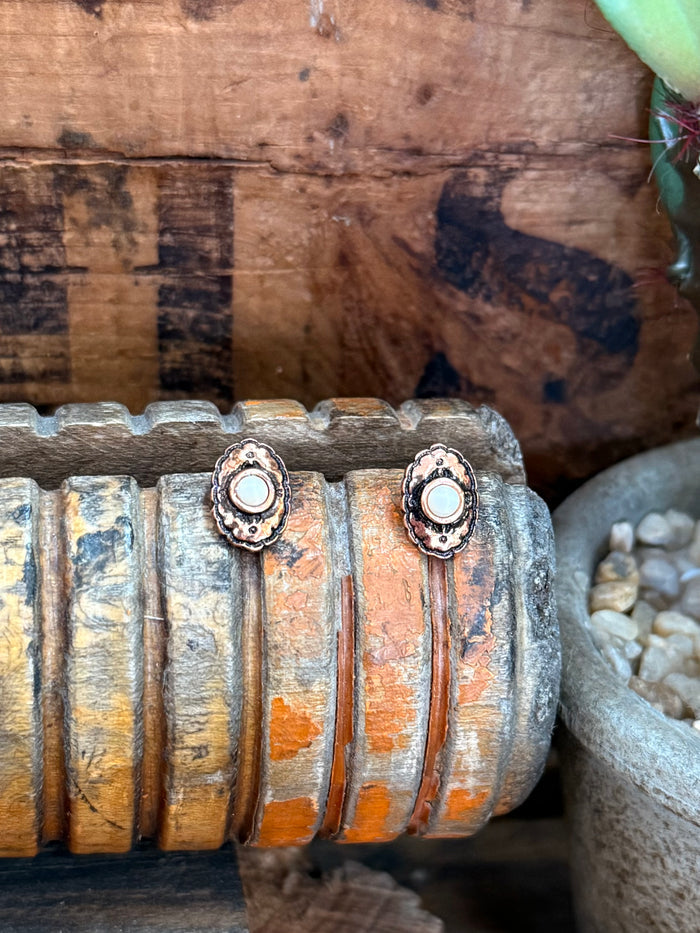 Round copper concho stud earrings with white center discs and detailed floral border