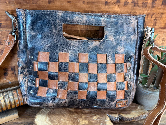 Distressed blue crossbody bag with tan checkerboard front panel and metal stud details