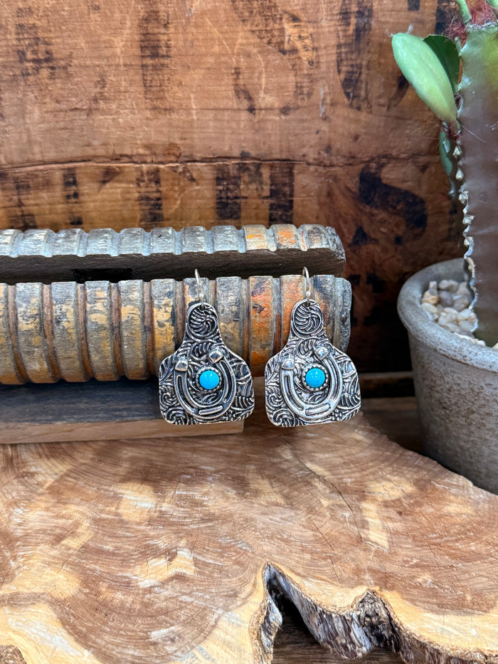 Ornate silver horseshoe drop earrings with turquoise cabochon center stones