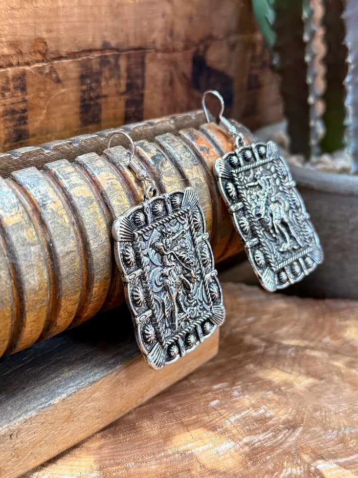 Silver-tone rectangular dangling earrings with crowned relief pattern and textured edging