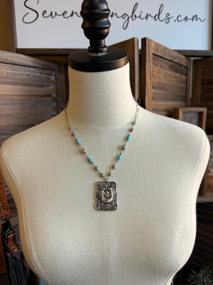 Silver-tone beaded necklace with turquoise accents and horse-shoe pendant