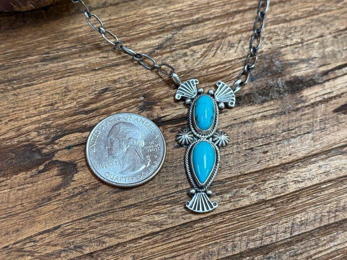 Turquoise oval pendant necklace with silver stamped accents and two cabochons