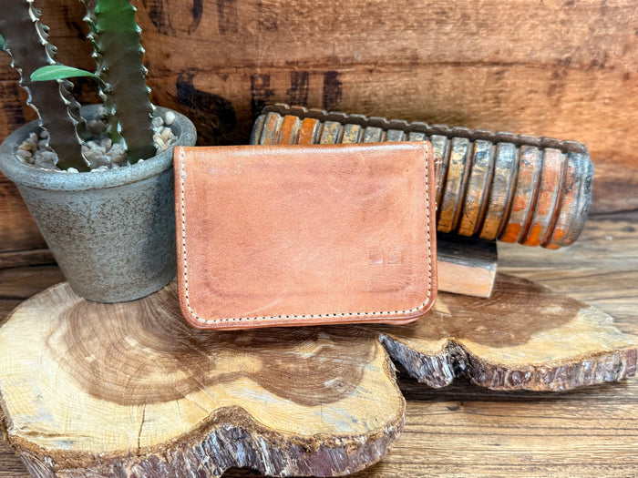Tan leather wallet front flap with contrast stitching and rounded corners