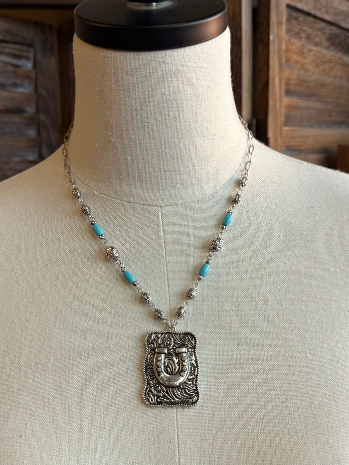 Silver-tone beaded necklace with turquoise beads and engraved horse-shoe pendant