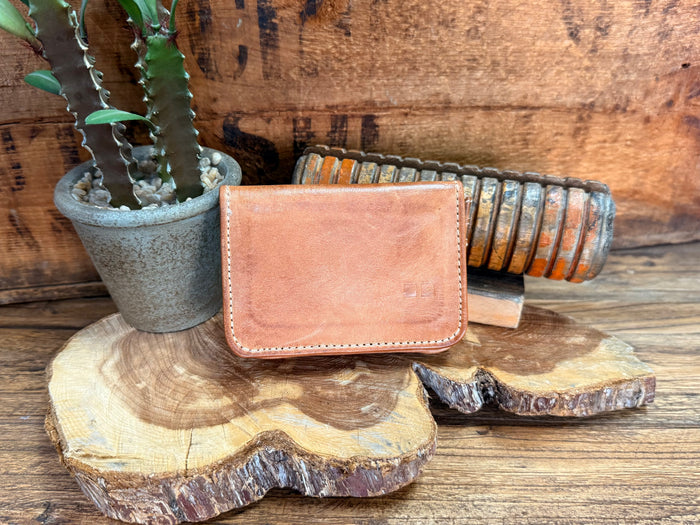 Tan leather bifold wallet with stitched edge and front flap