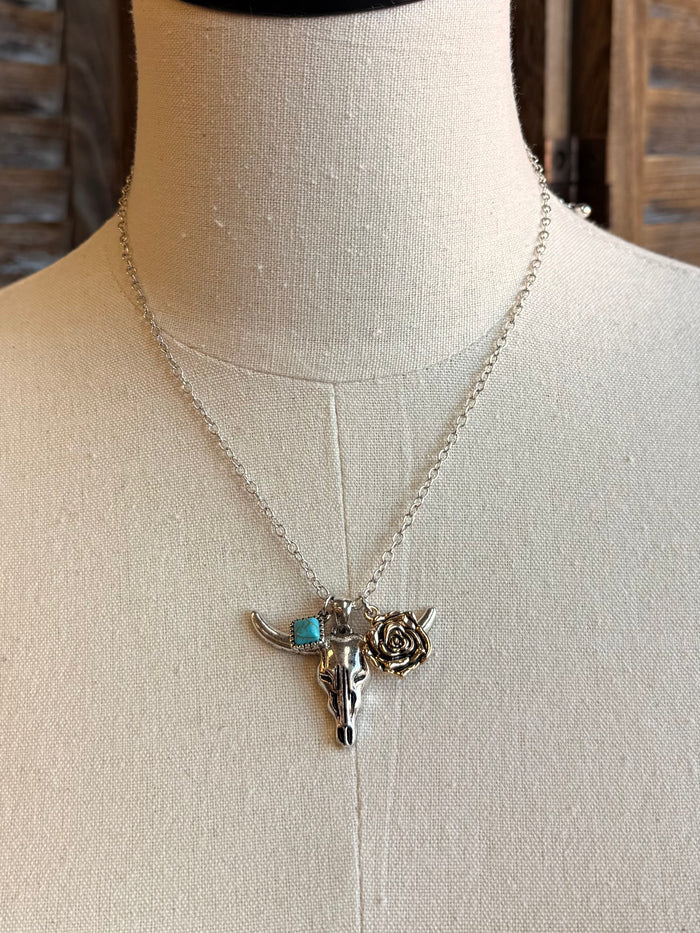 Silver chain necklace with cow skull charm, turquoise blue stone, and rose detail