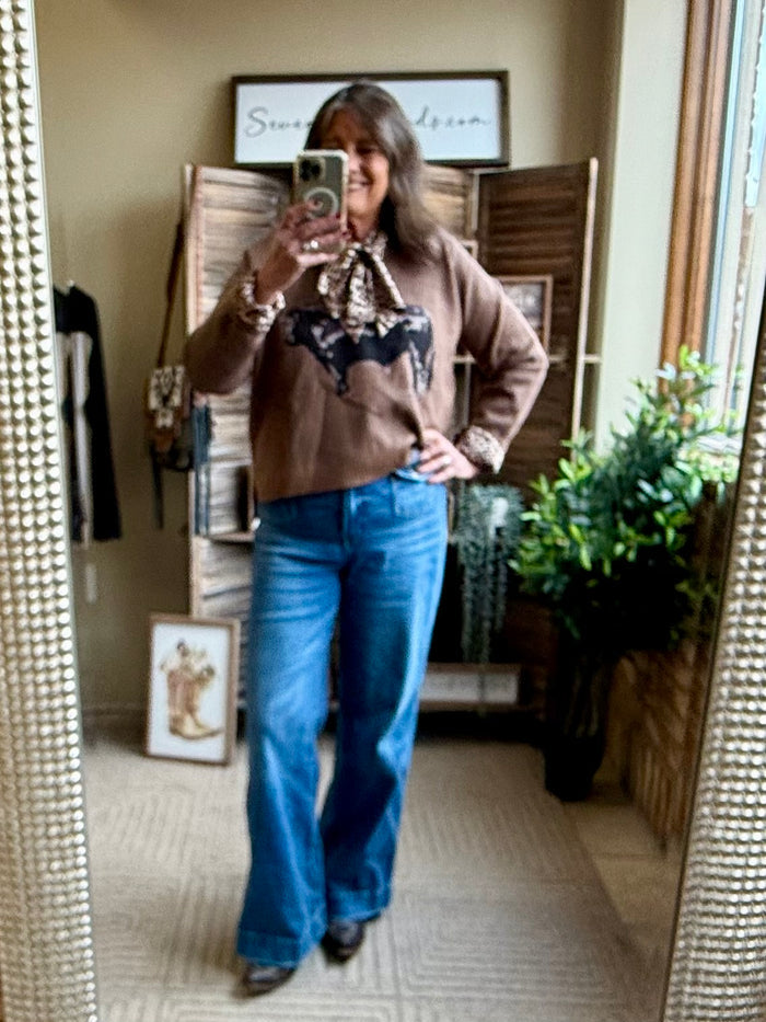 Taupe ribbed V-neck sweater with long sleeves and centered Angus cow graphic