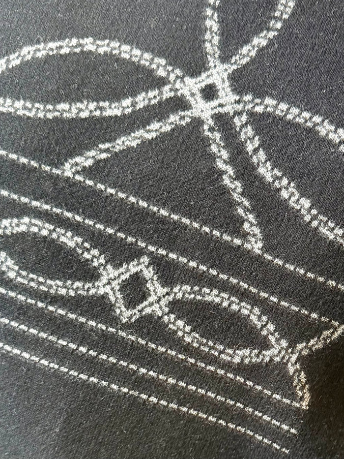 Dark sweater with white stitched geometric Nordic pattern detail