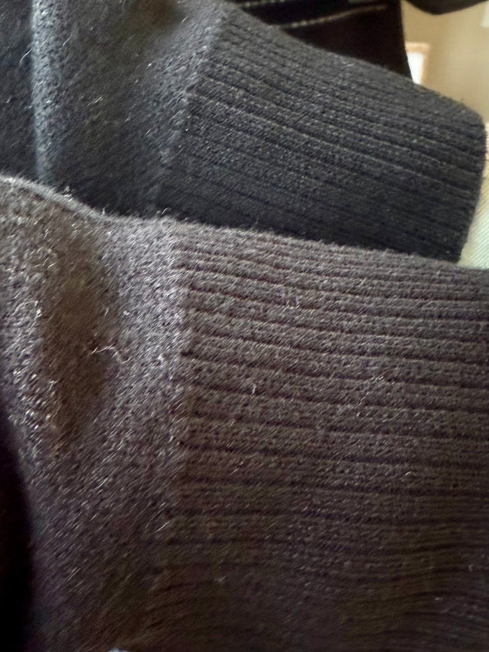 Dark sweater knit fabric close-up with visible textured weave