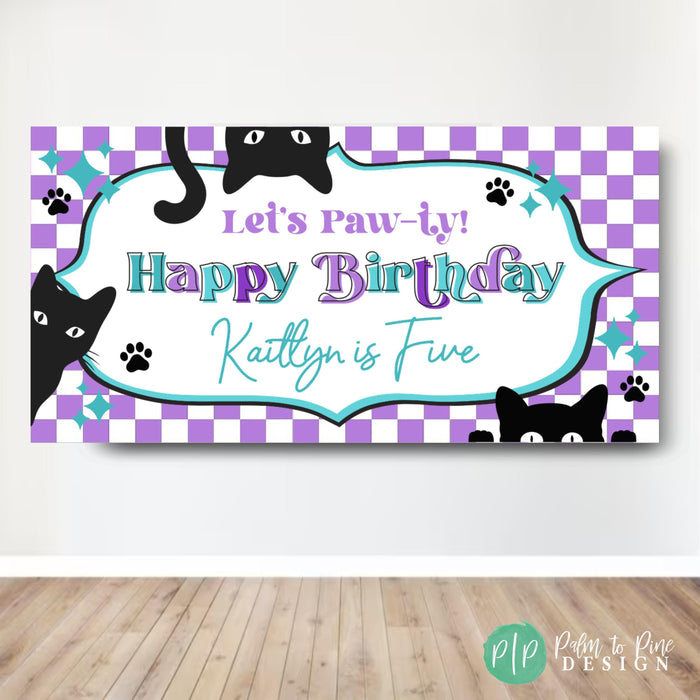 Custom vinyl birthday banner with cat theme featuring 'Let's Paw-ty! Happy Birthday text and personalized name, purple and teal colors, black cat silhouettes, and paw prints against a white brick wall backdrop