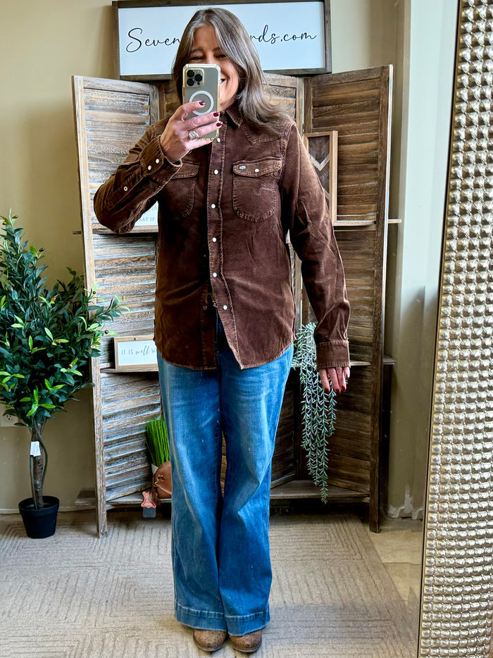 Dark brown corduroy shirt worn with blue jeans, long sleeves and button-front