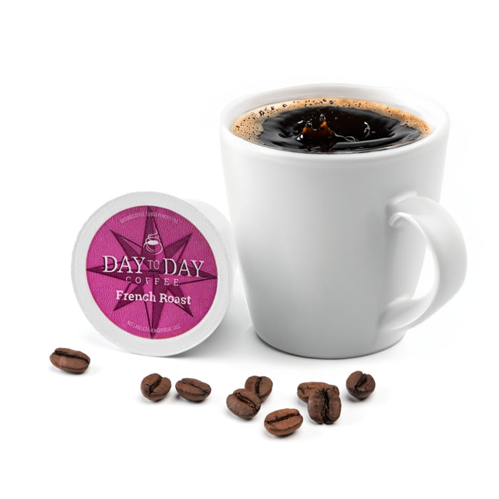 White mug with coffee, Day to Day Coffee French Roast pod, and scattered coffee beans on a white background