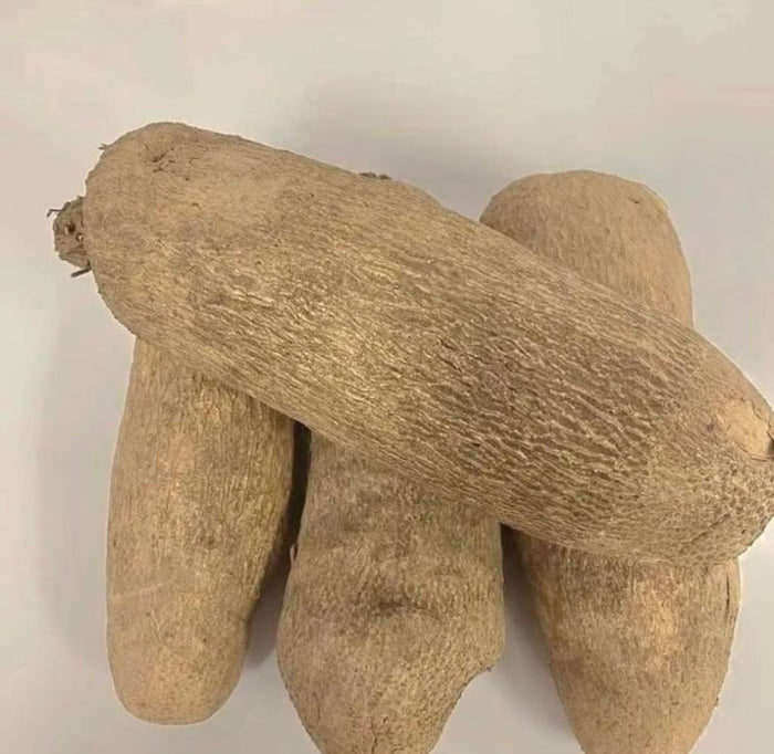 Fresh African yams (Ghana yams), 2 to 3 large brown tubers weighing approximately 7.5 pounds, displayed on a clean surface, showing rough textured skin typical of tropical root vegetables.