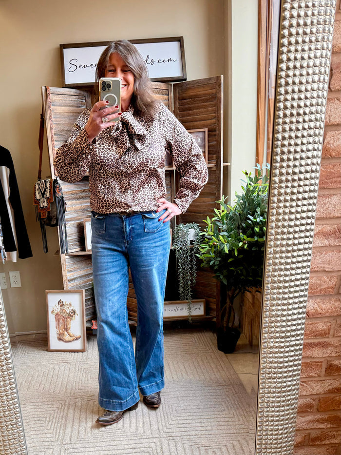 Leopard print bow tie blouse with long sleeves, gathered front, and button cuffs