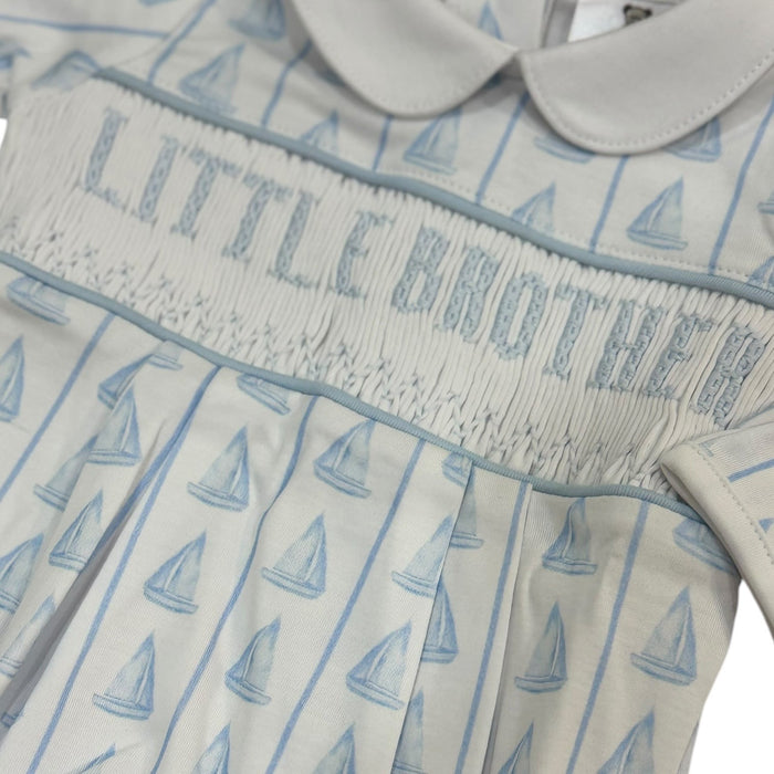 Close-up of handsmocked “LITTLE BROTHER” lettering and blue sailboat print