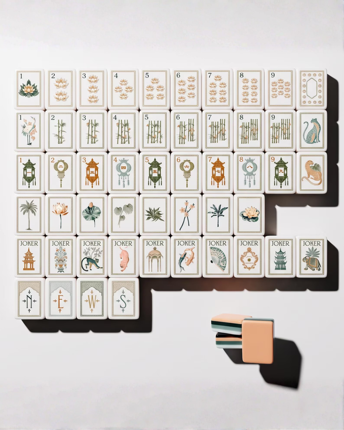 Mahjong tile assortment with number and suit faces and peach tile backs