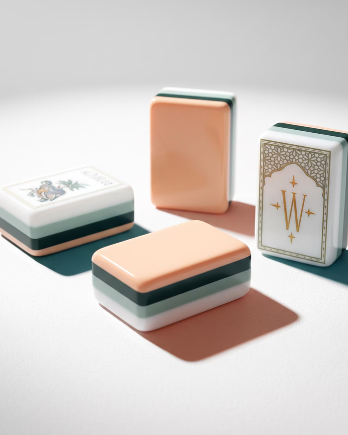 Stacked mahjong tiles with peach backs and dark green bases