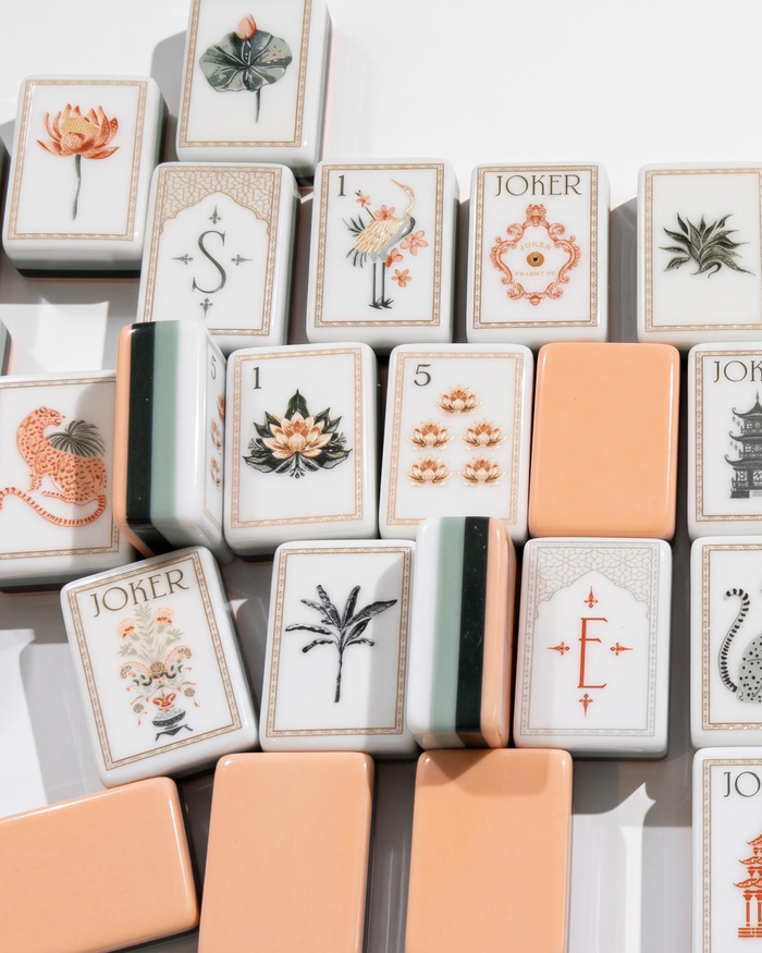 Mahjong tiles with illustrated suits and Joker cards, plus peach-colored backs
