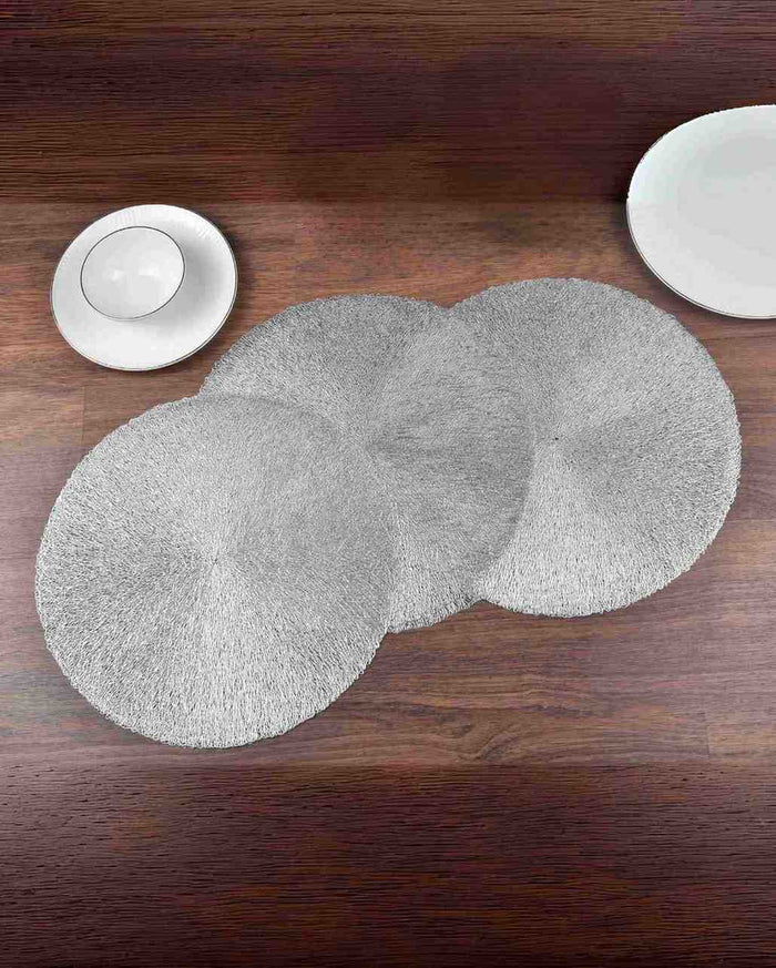 Silver table mat set of two overlapping round mats on tabletop