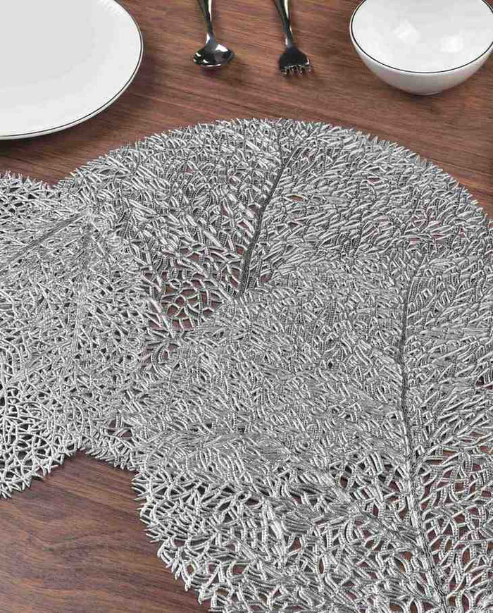 Silver round metallic placemat with detailed woven filaments and raised leaf texture