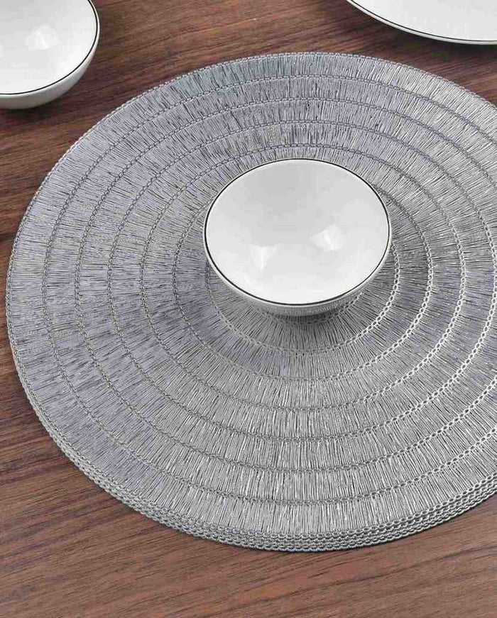 Silver round textured placemat featuring concentric ring weave detail