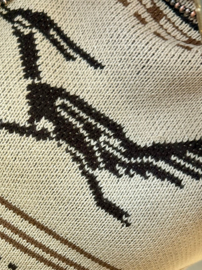 Tan knit sweater fabric with bold black and cream Fair Isle stripes and diamonds.