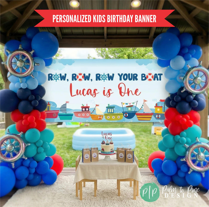 Sailboat birthday party for boys, set in backyard with personalized row your boat banner and nautical themed balloon garland