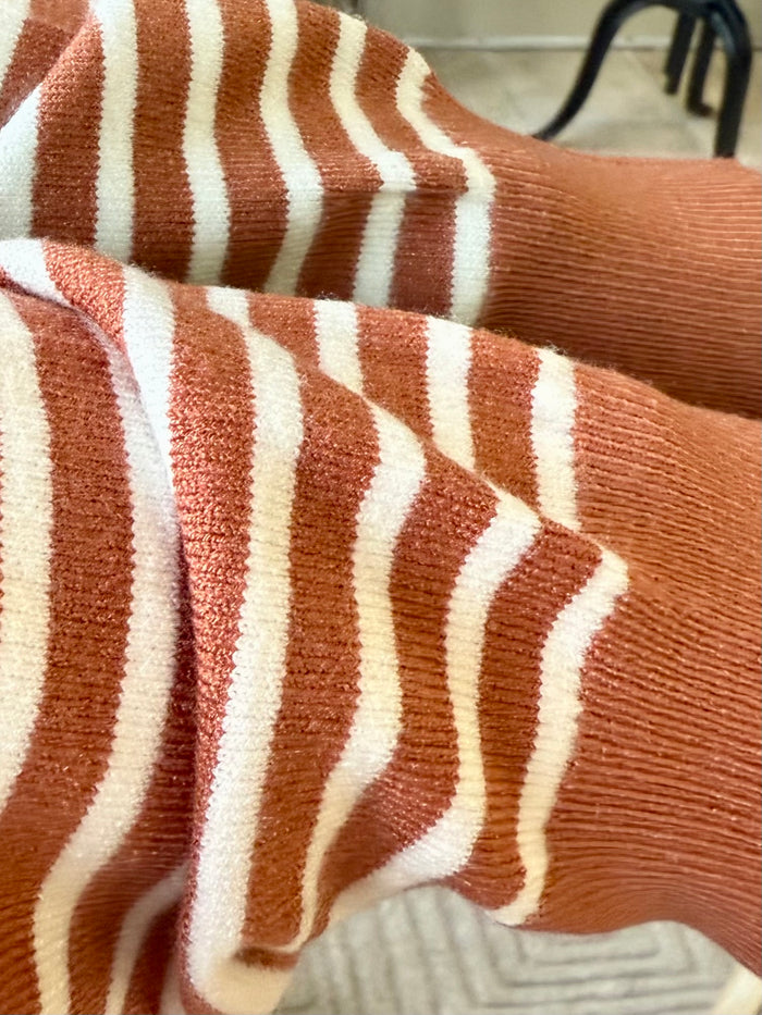 Rust and white striped knit sweater sleeve detail