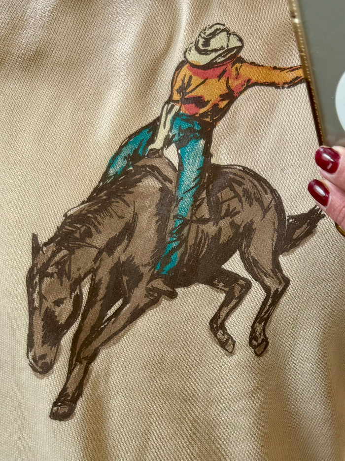 Close-up of western saddle bronc embroidered horse and rider on light knit