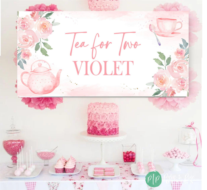 A pink and white tea party banner with the text 'Tea for Two' and personalized with name and watercolor floral designs. The banner is hanging above a table with pink and white decorations, including a pink ombre cake, pink and white cupcakes, and pink and white candy.