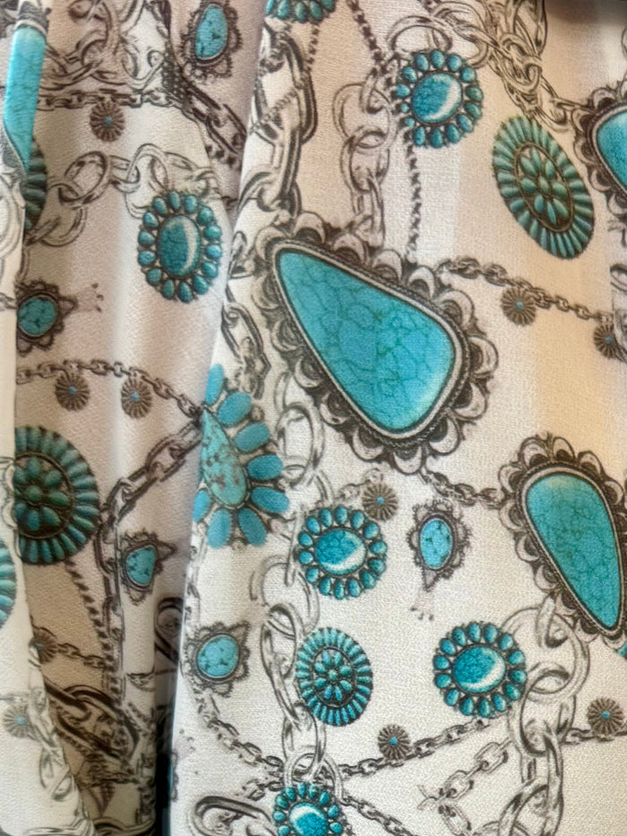 Close-up of turquoise and cream ornate geometric print blouse fabric