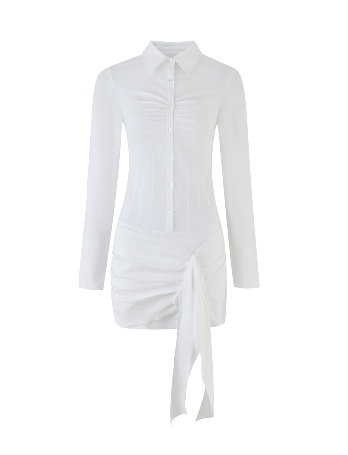 The ZADIE SHIRT DRESS - WHITE by TIGERMIST is a mini-length white cotton poplin dress featuring long sleeves, a button-down front, ruched detail, and an asymmetrical draped skirt.